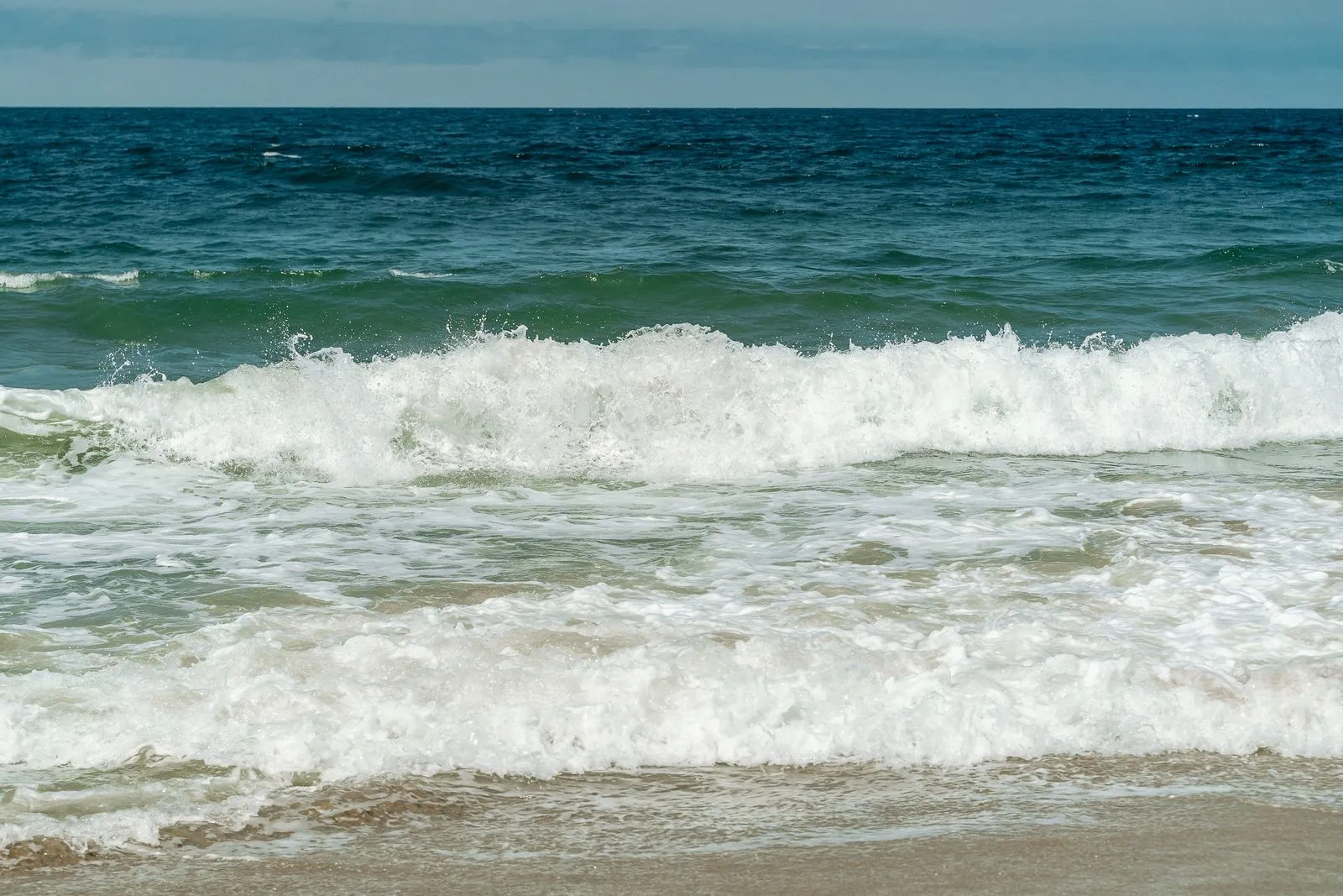 Waves rolling onto a beach one after another — a metaphor for the ISO 14025:2026 transition reaching EPD programmes in waves