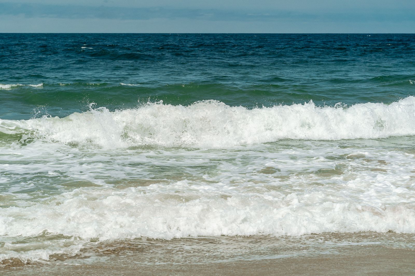 Waves rolling onto a beach one after another — a metaphor for the ISO 14025:2026 transition reaching EPD programmes in waves